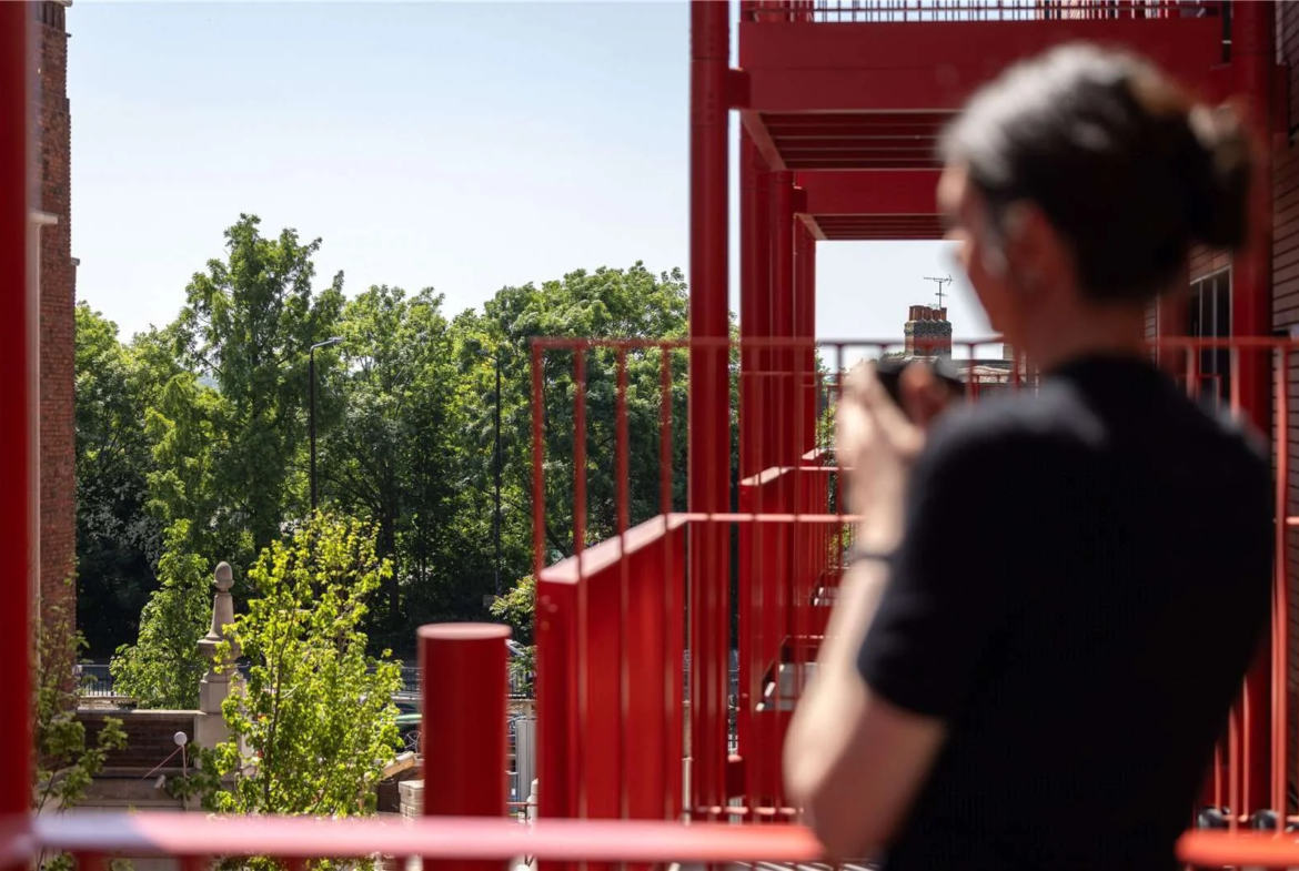 Artisi Hammersmith Civic Campus London W6 Red Steel Balcony Man Photographing Green Tree Views