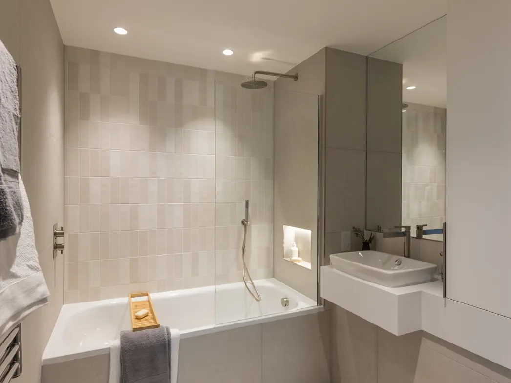 Artisi Hammersmith Town Hall London W6 2 Bed Apartment Main Bathroom Bathtub Overhead Shower Cream Tiles Full Mirror