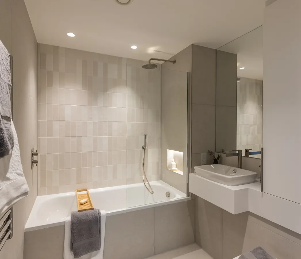 Artisi Hammersmith Town Hall London W6 2 Bed Apartment Main Bathroom Bathtub Overhead Shower Cream Tiles Full Mirror