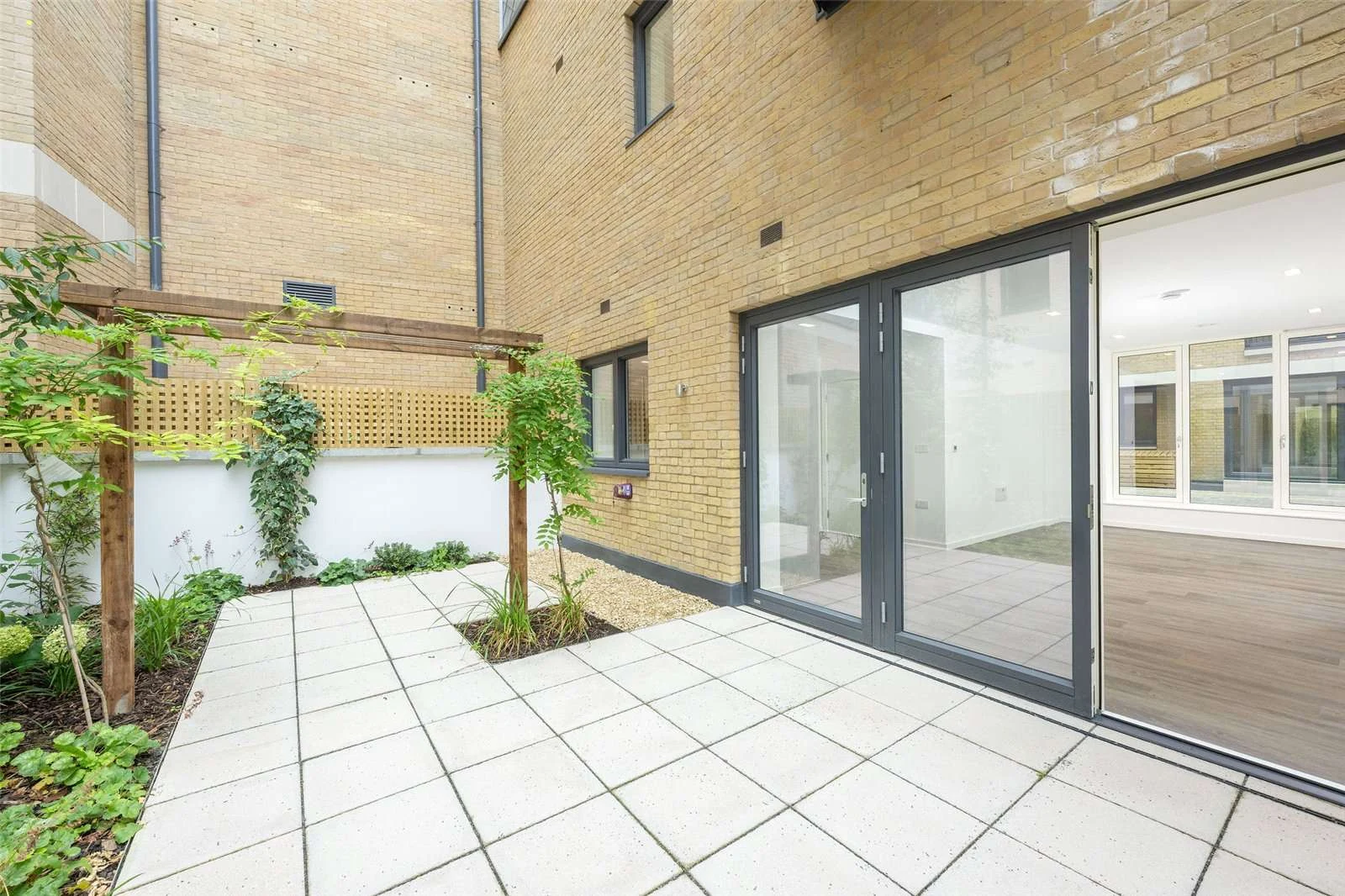 The Auria 2 Cantle Mews W10 Rear Garden Pergola Bifold Doors Yellow Brick Facade